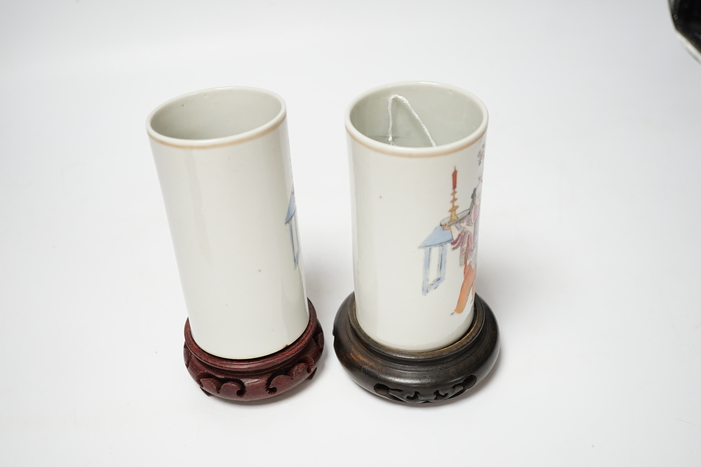 A pair of Chinese cylindrical famille rose brush pots on associated stands, largest 15cm high overall